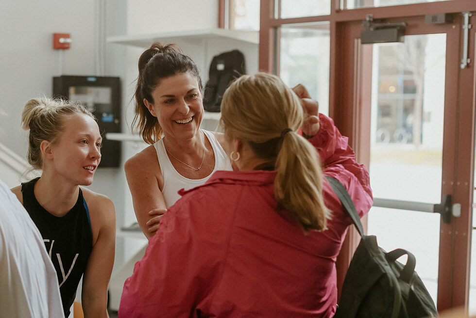 4 women talking in the lobby of a boutique fitness studio